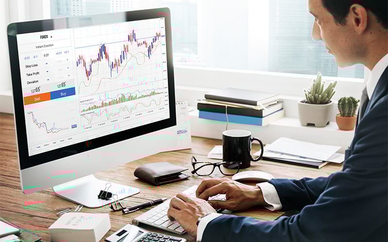 Trader analyzing Forex and futures charts at a desk