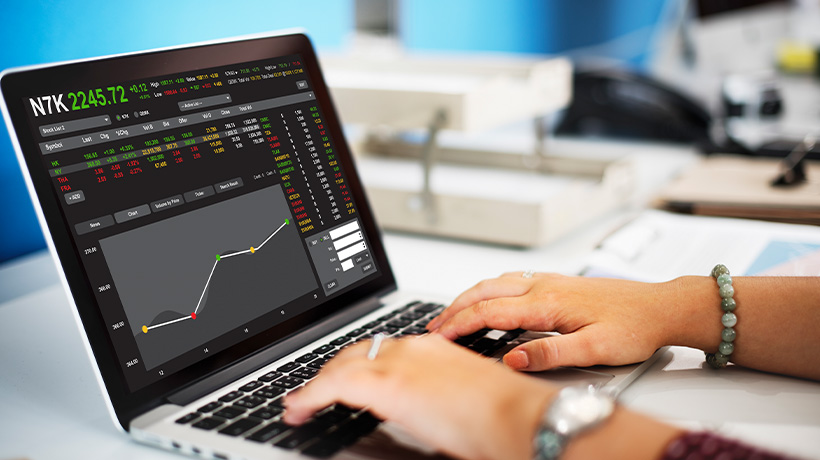 Trader analyzing complex financial performance charts on a laptop