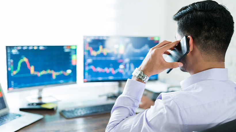 Professional trader monitoring real-time market data on multiple screens.