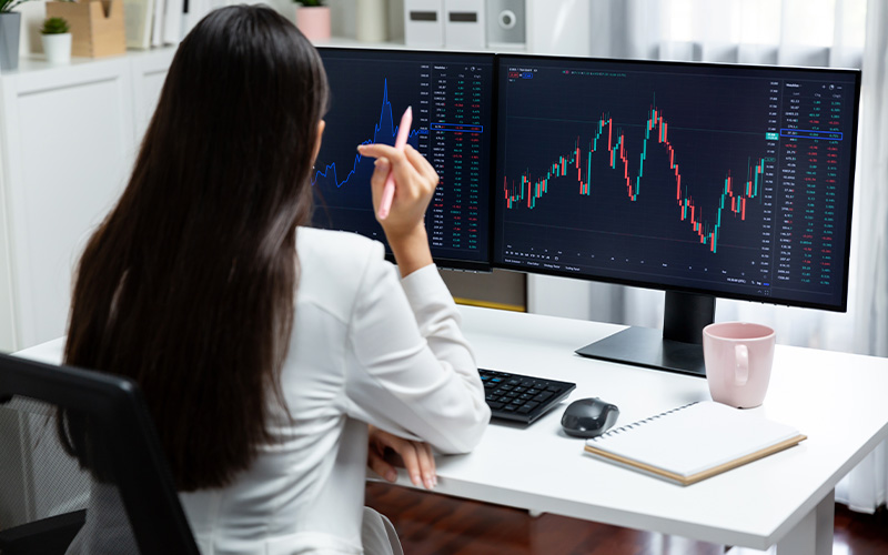 WeMasterTrade user analyzing long-term trading patterns on dual monitors.